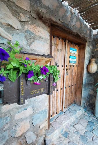 a door of a stone building with flowers on it at ROSES HOUSE OMAN in Jabal Al Akhdar