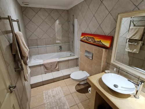ein Badezimmer mit einer Badewanne, einem WC und einem Waschbecken in der Unterkunft Palm Zicht in Kapstadt