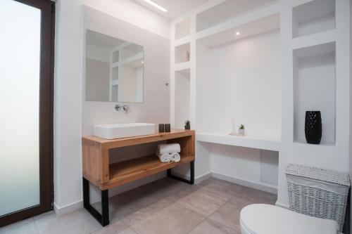 a bathroom with a sink and a mirror at Terra Pietra Luxury Villas & Suites in Lardos
