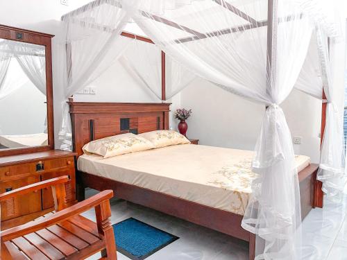 a bedroom with a bed and a mirror and a chair at Coco Mount Mirissa in Matara