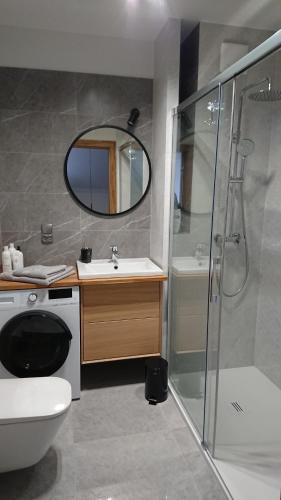 een badkamer met een douche, een toilet en een wastafel bij Apartamenty Color - Niebieski in Kielce