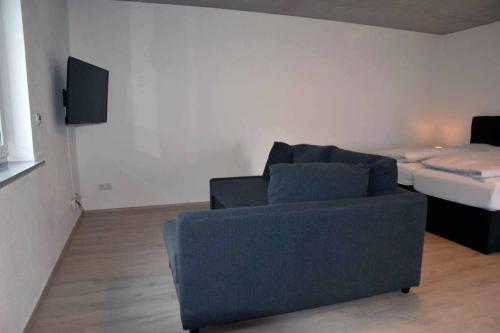 a living room with a couch and a bed at Ferienwohnung Steigerwaldblick in Dingolshausen