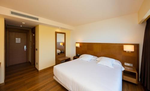 a hotel room with a large bed and a mirror at Hotel Thalasso Cantabrico Las Sirenas 4 Superior in Viveiro