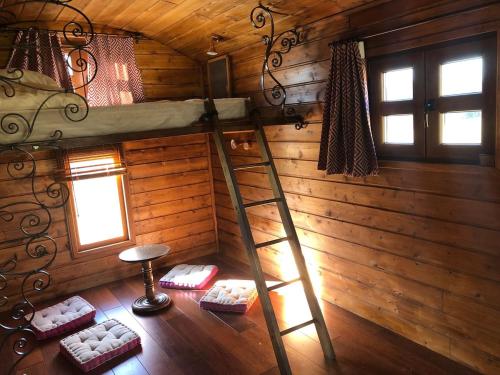 una habitación con una escalera en una cabaña de madera en Les roulottes de cirque Les Settons en Moux-en-Morvan