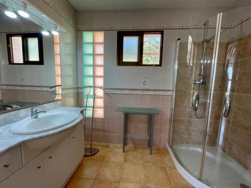 a bathroom with a sink and a shower and a tub at Villa June in Benitachell