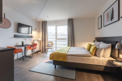 ein Hotelzimmer mit einem Bett, einem Tisch und Stühlen in der Unterkunft acora Berlin Living the City in Berlin