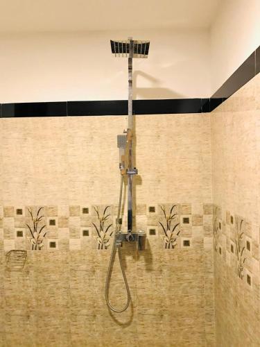 a shower in a bathroom with a wall at Ella Sandy Heaven Homestay in Ella