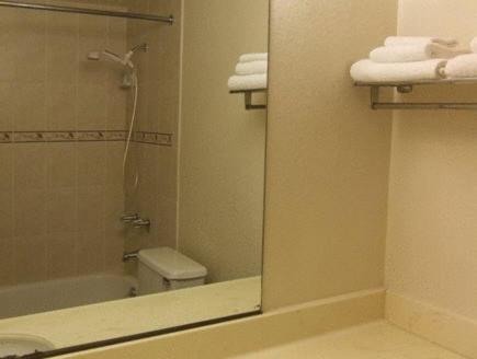 a bathroom with a mirror and a toilet and a sink at Cozy Inn in Costa Mesa