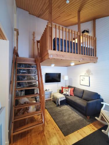 a living room with a staircase and a couch at Winter Nest - A cozy accommodation in the heart of Saariselkä in Saariselka