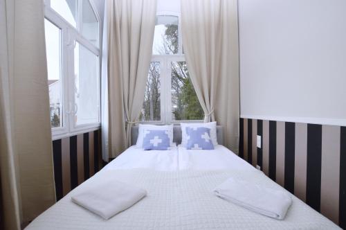 een slaapkamer met een bed met 2 kussens en een raam bij Victus Apartamenty, Apartamenty Manhattan in Sopot