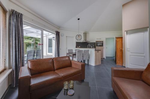 a living room with a couch and a table at Bungalowpark Het Verscholen Dorp in Harderwijk