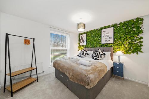 a bedroom with a bed and a green wall at Stylish 2 Bedroom 2 Bathroom Apartment - 8 Minutes Drive to Central MK - Free Parking, Fast WiFi & Smart TV by Yoko Property in Milton Keynes