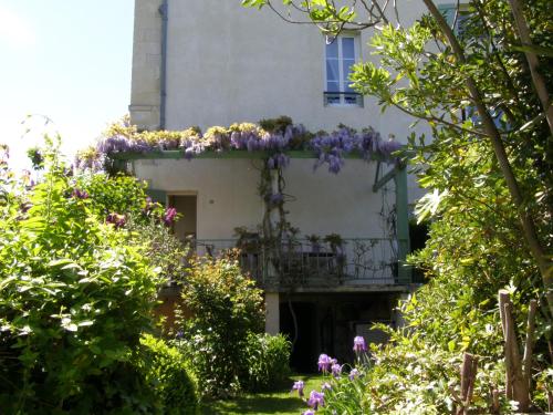 a building with a balcony with purple flowers on it at Beautiful large stylish villa centrally located in Pons in Pons