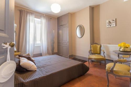 1 dormitorio con cama, mesa y ventana en Les Hortensias, en Nolay