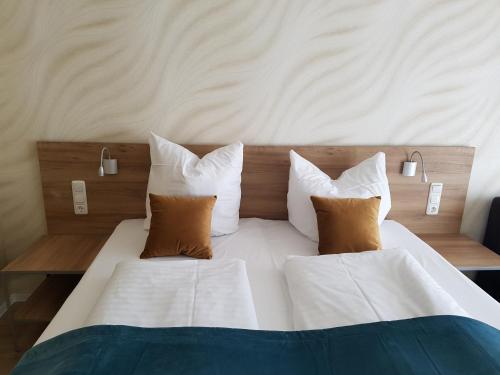 1 dormitorio con cama blanca y almohadas marrones en FeWo Nina Exklusiv Design mit Bergblick, en Goslar