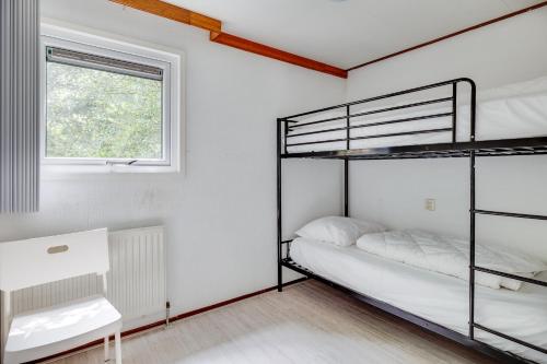 a bedroom with two bunk beds and a window at Bungalowpark Het Verscholen Dorp in Harderwijk