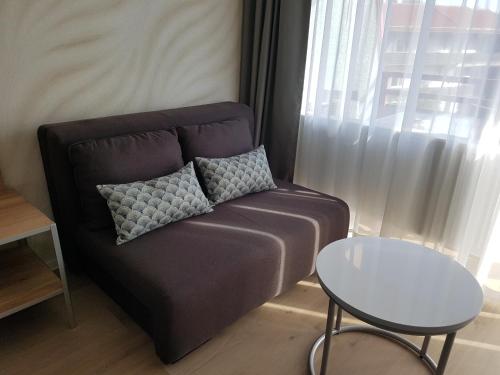 a couch with a pillow and a table in a room at FeWo Nina Exklusiv Design mit Bergblick in Goslar