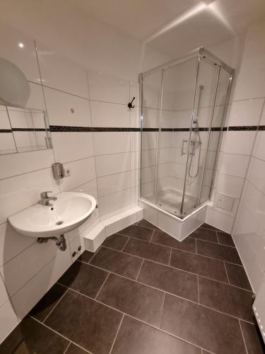 La salle de bains est pourvue d'une douche et d'un lavabo. dans l'établissement Puschkin Rooms, à Berlin