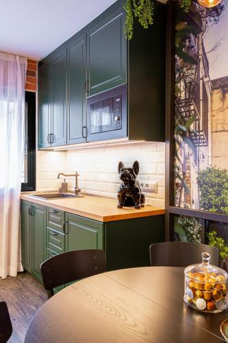 a kitchen with green cabinets and a teddy bear on the counter at Fly Rooms Madrid Airport in Madrid