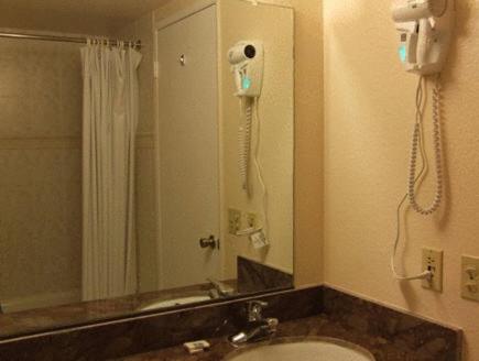 a bathroom with a shower and a phone on the wall at Cozy Inn in Costa Mesa