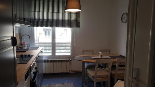 cocina con mesa, sillas y ventana en Superbe appartement au hypercentre de Chambéry en Chambéry