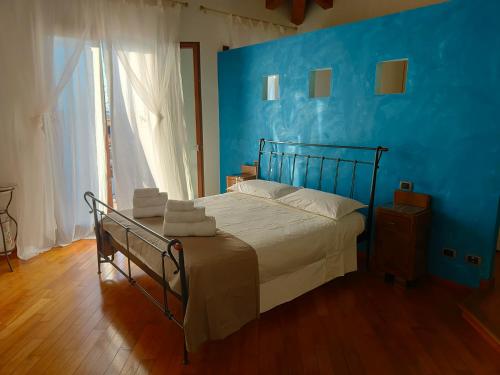 a bedroom with a bed with a blue wall at B&B Villa Letizia in San Vito Rimini