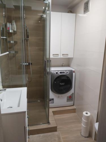 a small bathroom with a shower and a microwave at Apartament IZBA - mieszkanie na doby GDAŃSK in Gdańsk