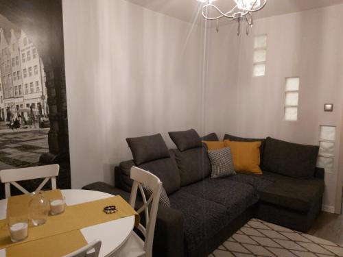 a living room with a couch and a table at Apartament IZBA - mieszkanie na doby GDAŃSK in Gdańsk