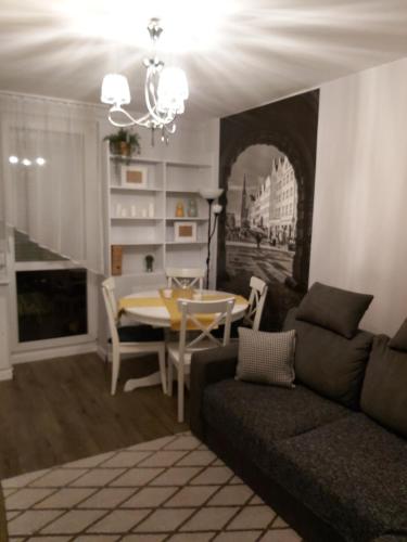 a living room with a couch and a table at Apartament IZBA - mieszkanie na doby GDAŃSK in Gdańsk