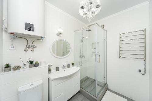 a white bathroom with a shower and a sink at Apartments Park Fountains in Liski