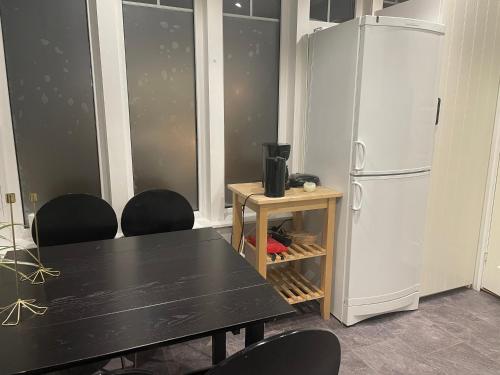a dining room with a table and a refrigerator at Villa Båthamnsgatan in Söråker
