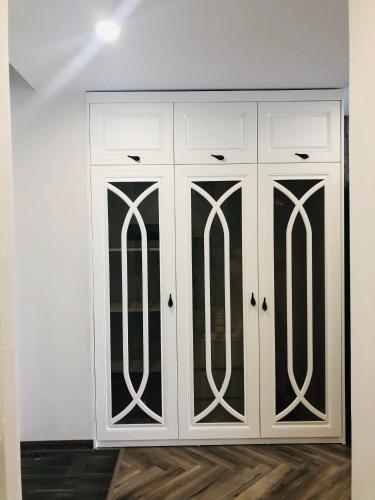 a white cabinet with black doors in a room at Gold Coast Luxury Apartment Nha Trang in Nha Trang
