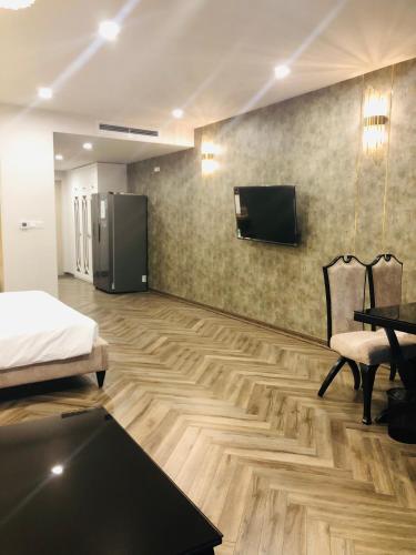 a room with a bed and a tv on the wall at Gold Coast Luxury Apartment Nha Trang in Nha Trang