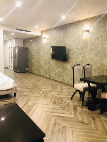 a living room with a table and a refrigerator at Gold Coast Luxury Apartment Nha Trang in Nha Trang