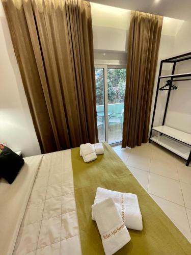 a bedroom with a bed with two towels on it at Relax Apts Saranda in Sarandë