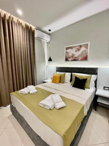 a bedroom with two beds with yellow and black pillows at Relax Apts Saranda in Sarandë