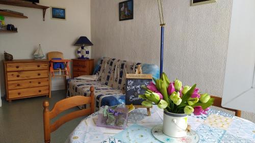 un salon avec une table avec un vase de fleurs dans l'établissement Terremer, au Tréport