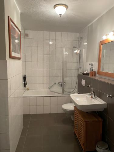 a bathroom with a sink and a tub and a toilet at Haus in der Gartenstadt in Bottrop