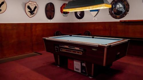 een pooltafel in een kamer met klokken aan de muur bij Maryfield House Hotel in Lerwick