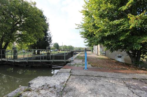 a canal with a blue pole in the water at Ecluse Mingot in Châtillon-en-Bazois