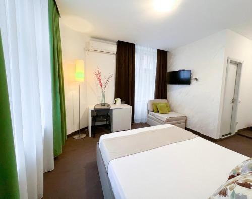 a hotel room with a white bed and a chair at Centar Forever in Belgrade