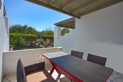 a wooden table and chairs on a balcony at To Pithari in Skiros