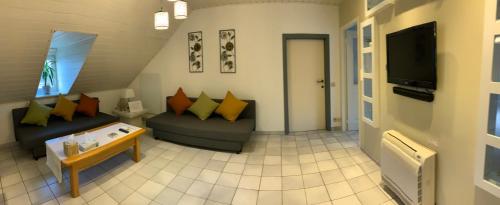 a living room with two couches and a tv at LinZn vakantiehuis in Wuustwezel