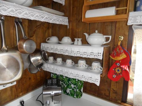 a kitchen with white shelves on the wall at villa Getty in Cala en Forcat