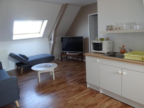 a kitchen and living room with a couch and a table at chambres d'hôtes près de FECAMP chez Muriel à Ganzeville le domaine de la roquette in Ganzeville