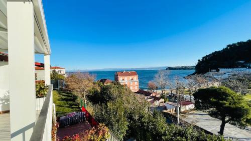 Una vista del agua desde el balcón de una casa. en Sunrise Fiesa, en Piran