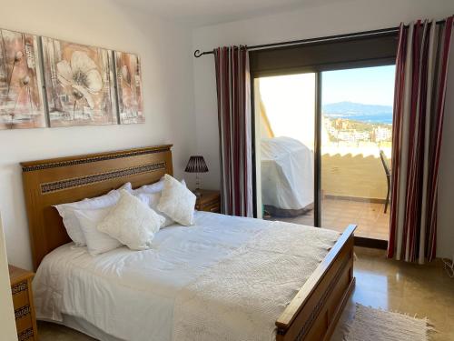 a bedroom with a bed with a view of a balcony at Duquesa village El Hacho in Manilva