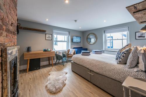 a bedroom with a bed and a fireplace at The Royal George in Appledore
