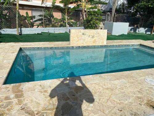 卡羅利納的住宿－Hermosa casa，站在游泳池旁的人的影子