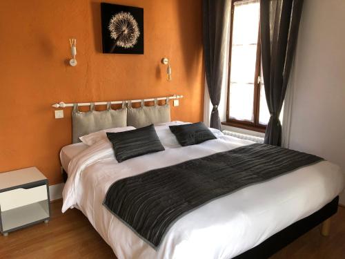 a bedroom with a large bed and a window at A l'Aube des Volcans in Charbonnières-les-Vieilles